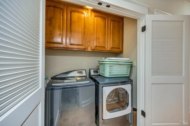 laundry room featuring washer and dryer and cabinets