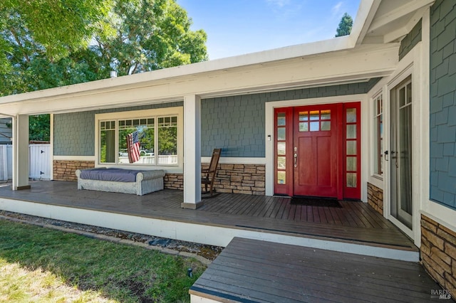 property entrance featuring stone siding and covered porch