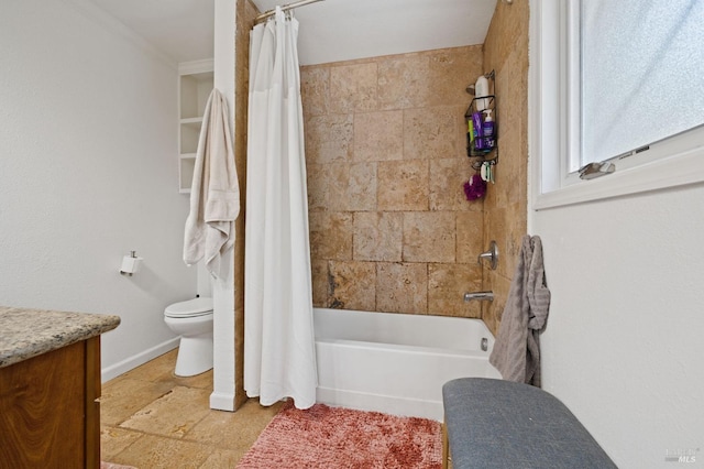 bathroom featuring toilet, stone tile floors, shower / bath combination with curtain, baseboards, and vanity