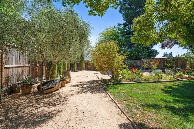 view of community with a lawn and a fenced backyard