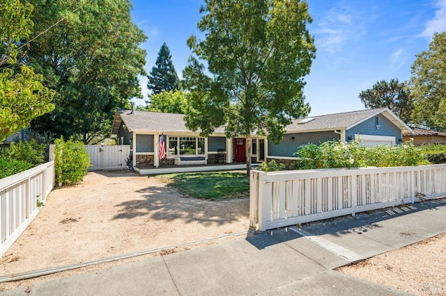 ranch-style home featuring a gate, a fenced front yard, and roof with shingles