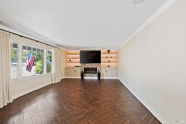 unfurnished living room featuring crown molding, baseboards, and a textured ceiling