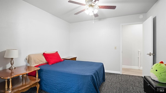 carpeted bedroom with ceiling fan and baseboards