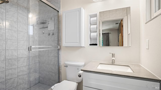 full bathroom featuring a stall shower, vanity, and toilet