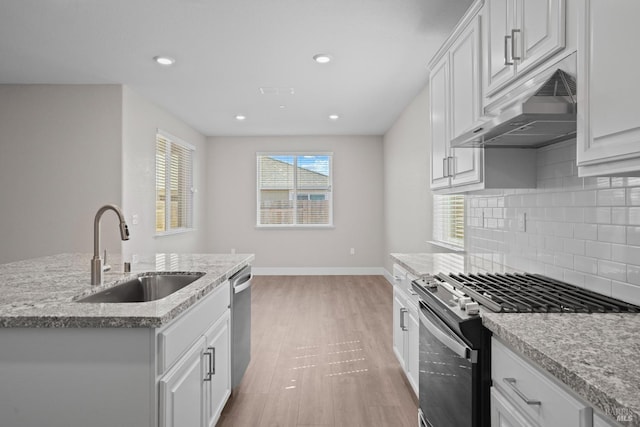 kitchen featuring ceiling fan, appliances with stainless steel finishes, plenty of natural light, and a kitchen island with sink