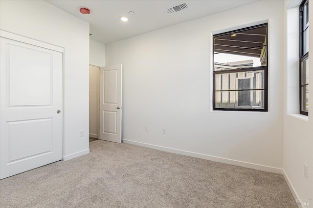 unfurnished bedroom featuring light carpet