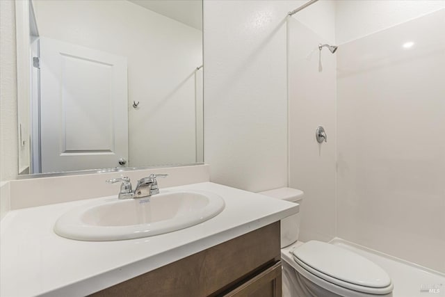 bathroom featuring walk in shower, vanity, and toilet