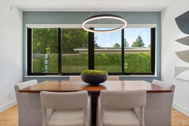 dining area with baseboards and wood finished floors