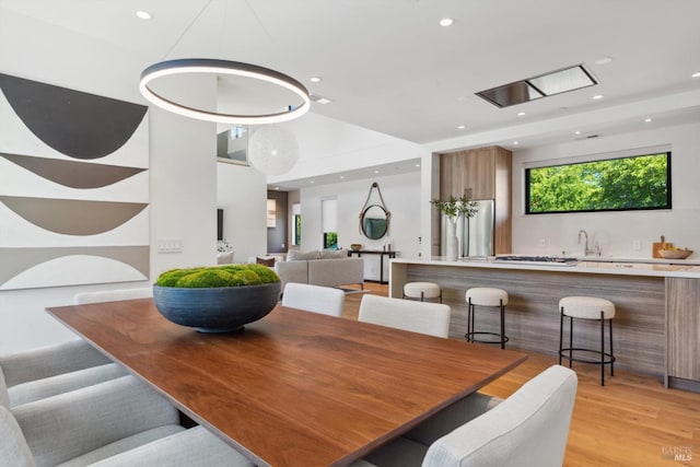 dining room with recessed lighting and light wood-style flooring