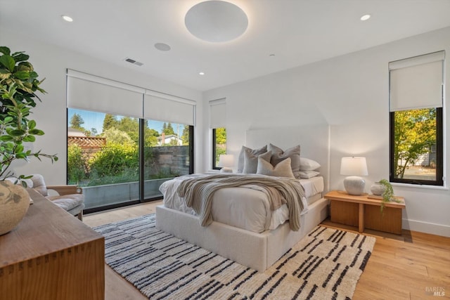 bedroom with access to exterior, recessed lighting, visible vents, and light wood finished floors