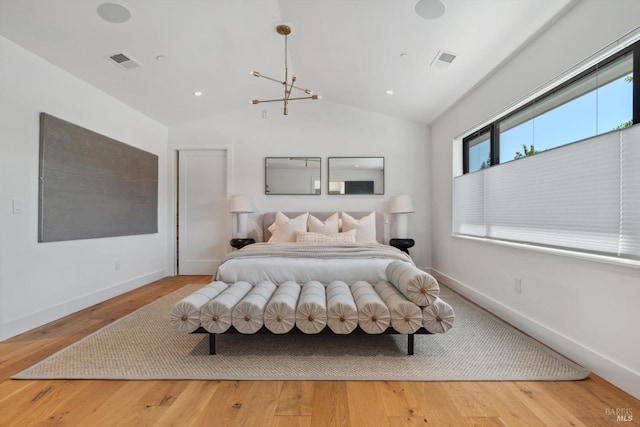 bedroom featuring lofted ceiling, wood finished floors, visible vents, and baseboards