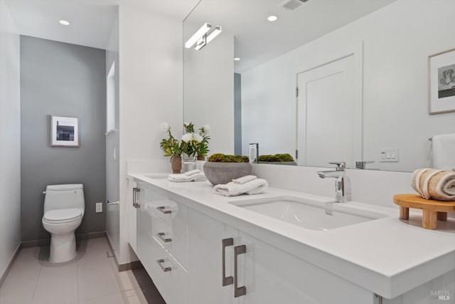 bathroom with double vanity, recessed lighting, toilet, a sink, and tile patterned flooring