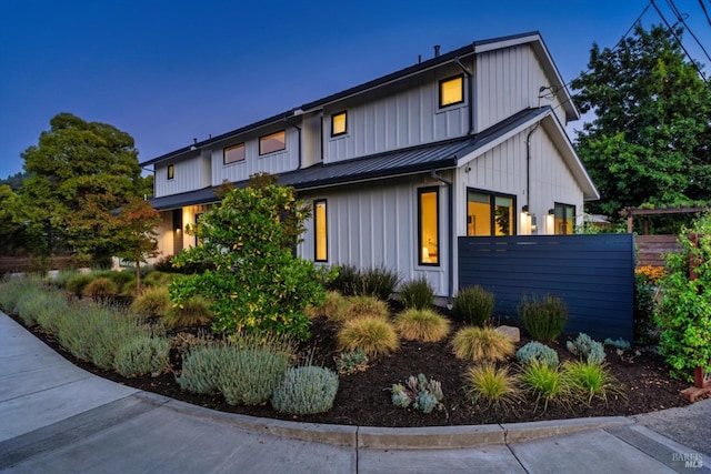 exterior space featuring a standing seam roof, fence, metal roof, and board and batten siding