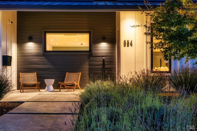 property entrance featuring a standing seam roof, a patio area, and metal roof