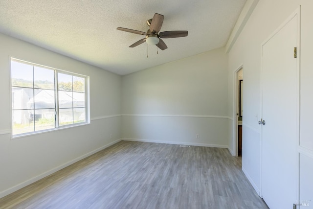 unfurnished room with hardwood / wood-style floors, ceiling fan, and a textured ceiling