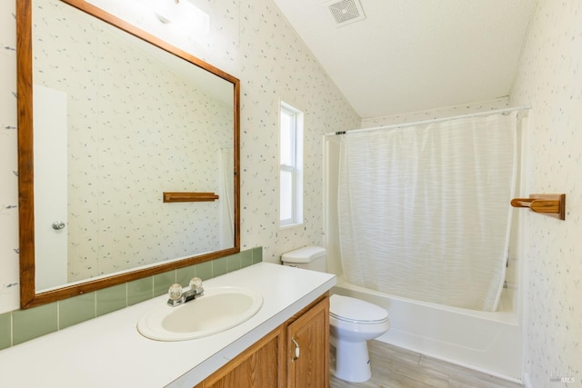 full bathroom with toilet, vanity, a textured ceiling, shower / bath combo with shower curtain, and lofted ceiling