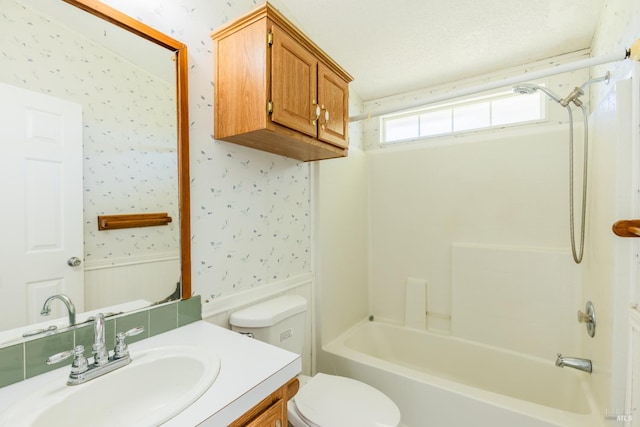 full bathroom with a textured ceiling, vanity, toilet, and  shower combination