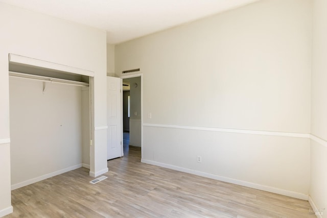 unfurnished bedroom featuring light wood-type flooring and a closet