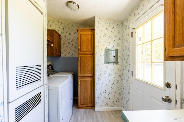 washroom with light wood-type flooring, electric panel, separate washer and dryer, cabinets, and a textured ceiling