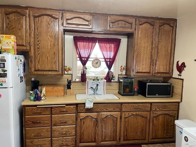 kitchen featuring white refrigerator and sink