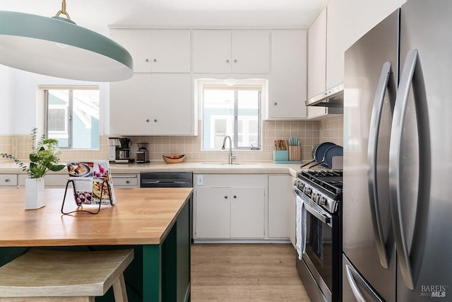 kitchen with sink, white cabinetry, stainless steel appliances, and plenty of natural light