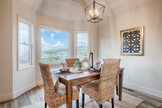 dining room with light wood finished floors, visible vents, baseboards, and a notable chandelier