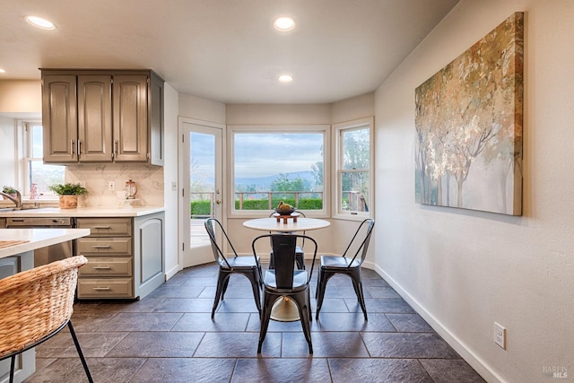 dining room with baseboards, recessed lighting, plenty of natural light, and stone tile floors