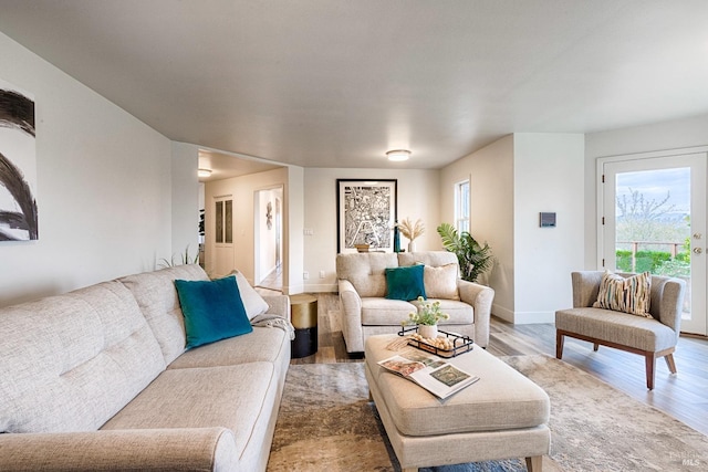 living area with light wood-type flooring and baseboards