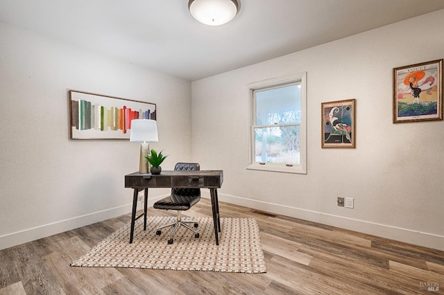 office with visible vents, baseboards, and wood finished floors