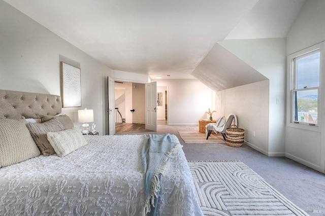 carpeted bedroom with baseboards and vaulted ceiling