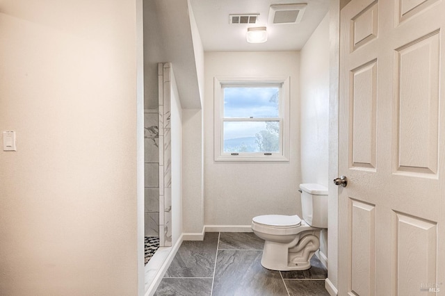 bathroom featuring baseboards, visible vents, a shower stall, and toilet