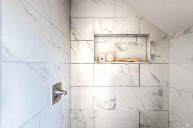 interior details featuring tiled shower