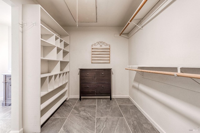 spacious closet featuring attic access