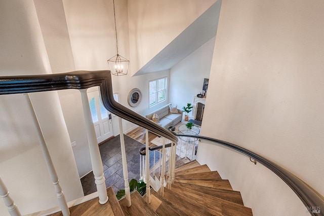 staircase with an inviting chandelier and wood finished floors