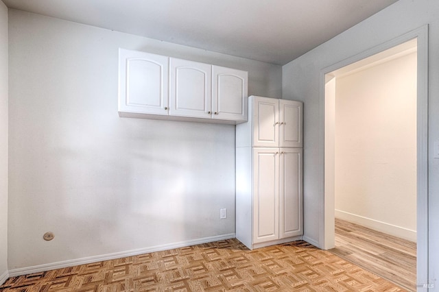 interior space featuring parquet flooring and baseboards