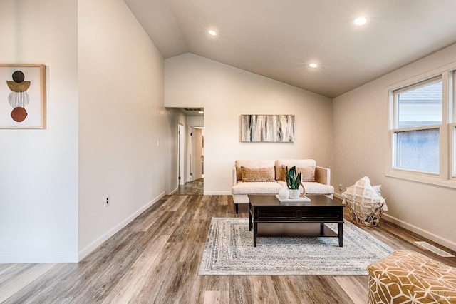 living area featuring vaulted ceiling, recessed lighting, wood finished floors, and baseboards