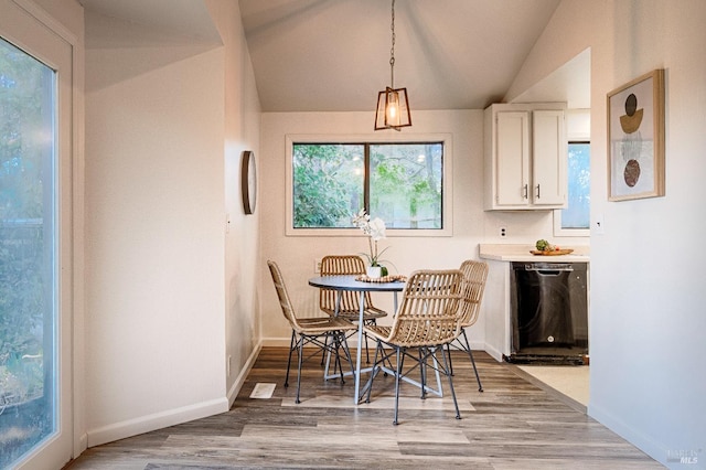 dining area with vaulted ceiling, baseboards, and light wood-style floors