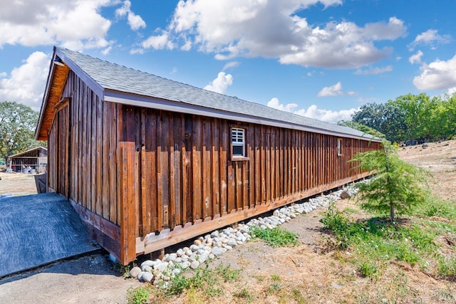 view of side of home with roof with shingles