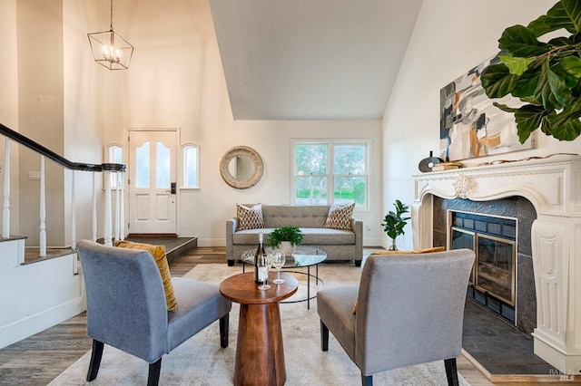 living area featuring stairway, a fireplace, wood finished floors, and baseboards