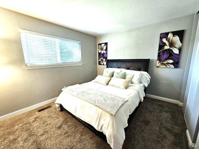 bedroom featuring dark colored carpet, visible vents, and baseboards