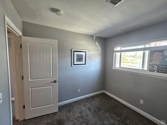 carpeted spare room featuring a textured ceiling