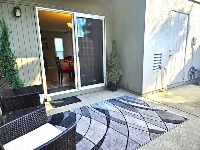 view of exterior entry featuring a patio area and stucco siding