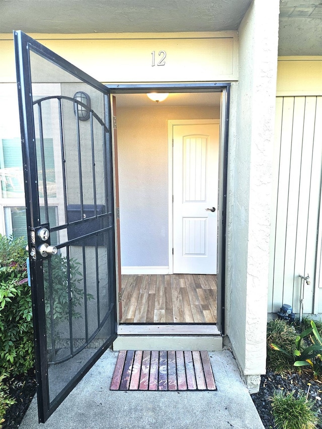 doorway to property featuring board and batten siding and stucco siding