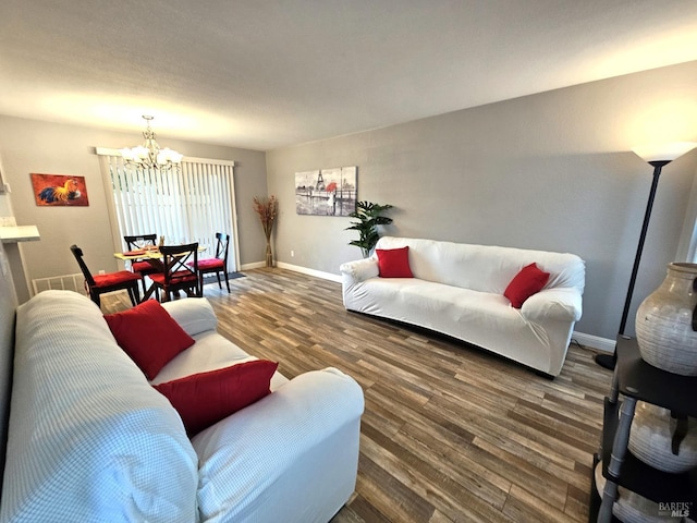 living area with visible vents, baseboards, dark wood finished floors, and a notable chandelier