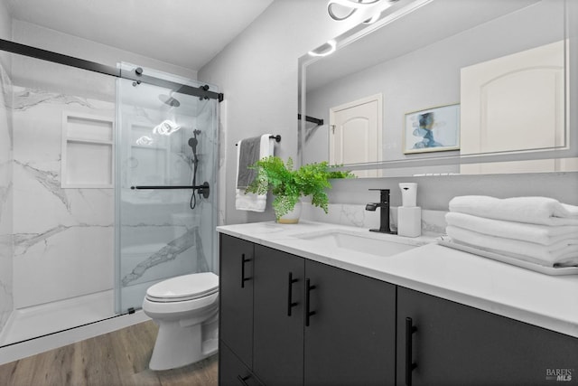 bathroom featuring vanity, toilet, an enclosed shower, and hardwood / wood-style floors