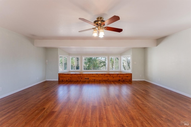 spare room featuring plenty of natural light, dark wood-type flooring, and lofted ceiling