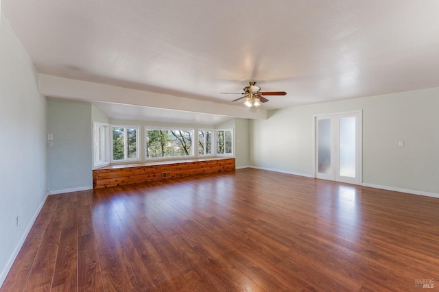 unfurnished living room with dark wood-type flooring and ceiling fan