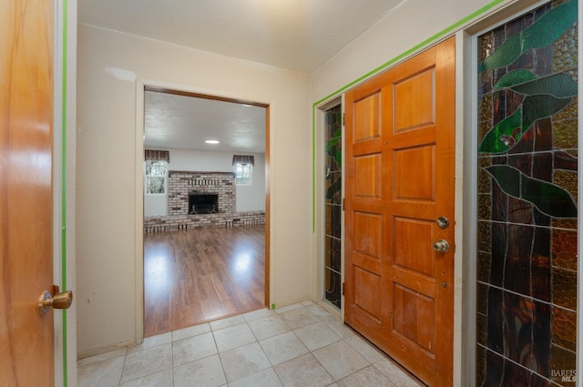 tiled entrance foyer featuring a textured ceiling and a fireplace