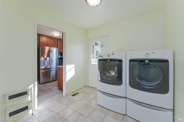 clothes washing area featuring light tile patterned flooring and washing machine and clothes dryer