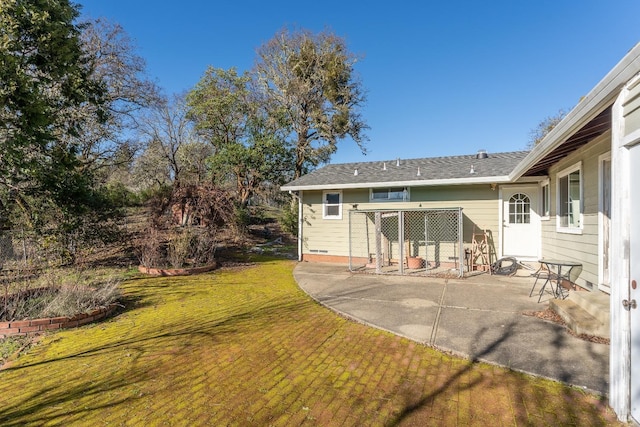 rear view of property featuring a lawn and a patio